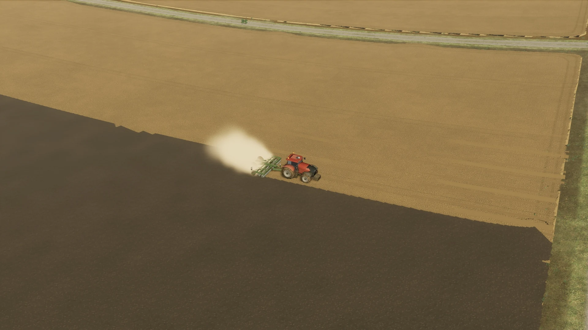 A red tractor pulls a lowered cultivator through stubble, leaving worked soil and dust behind it.