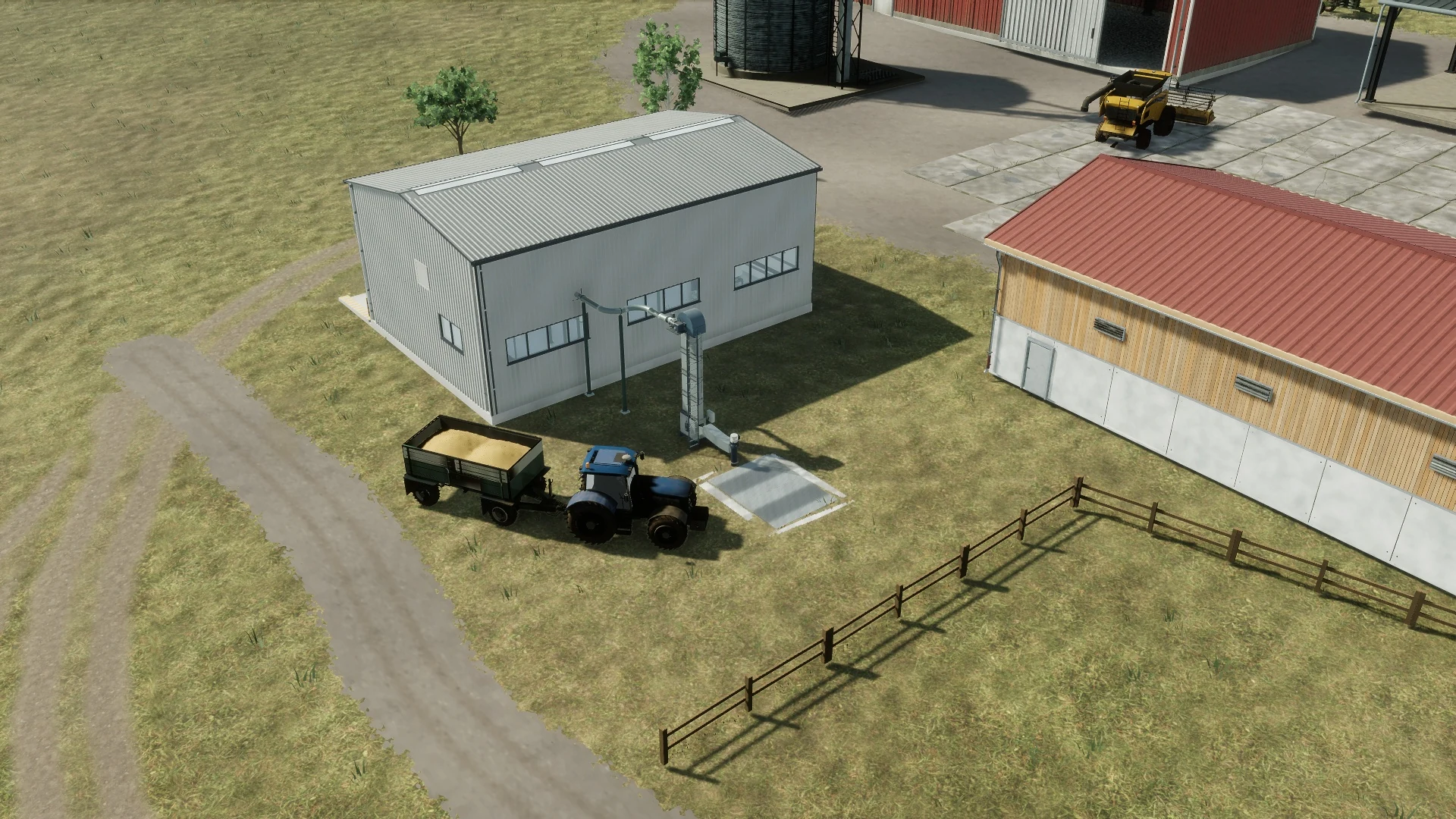 A tractor and grain-filled trailer arrive outside the mill, beside the outdoor grain intake.